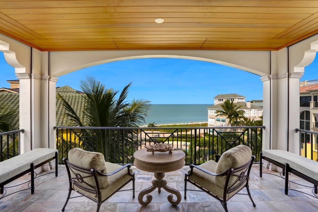 Chairs and table on a balcony overlooking the ocean at Florida vacation home