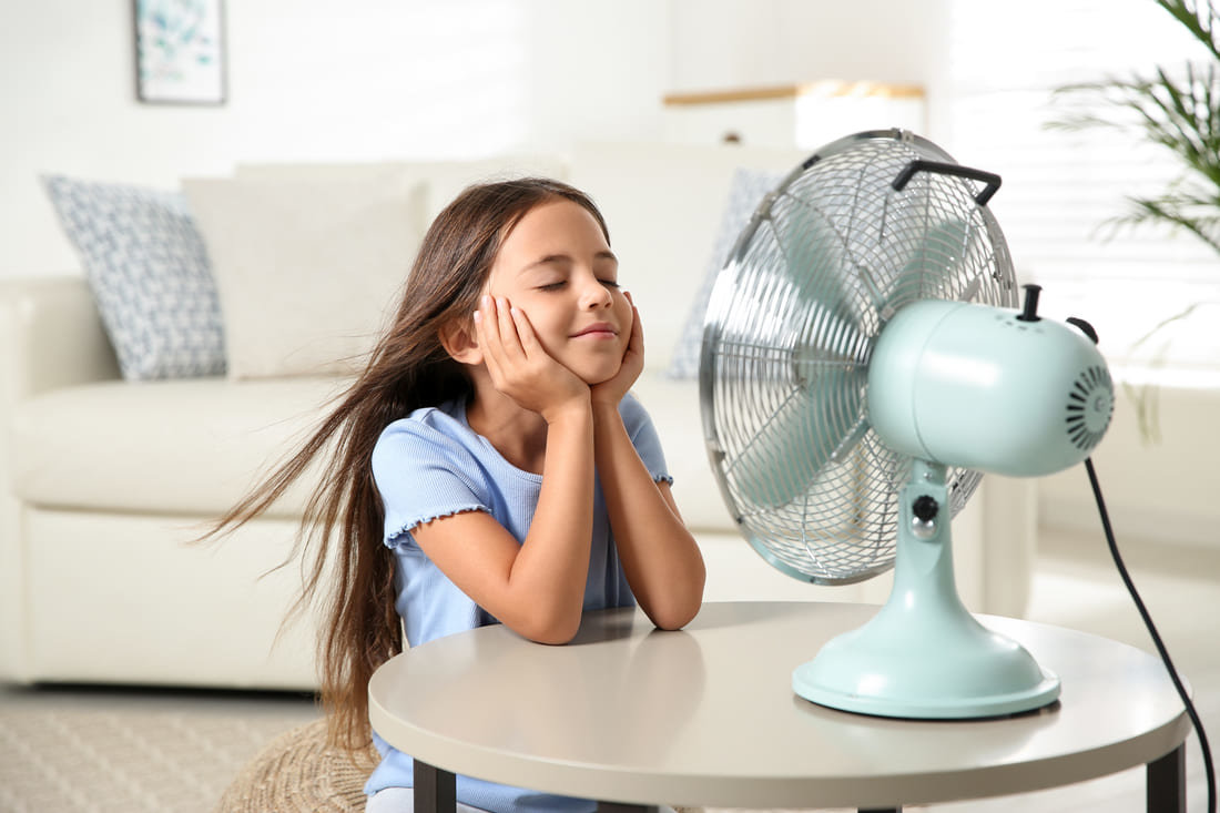 Girl cooling off in front of a fan