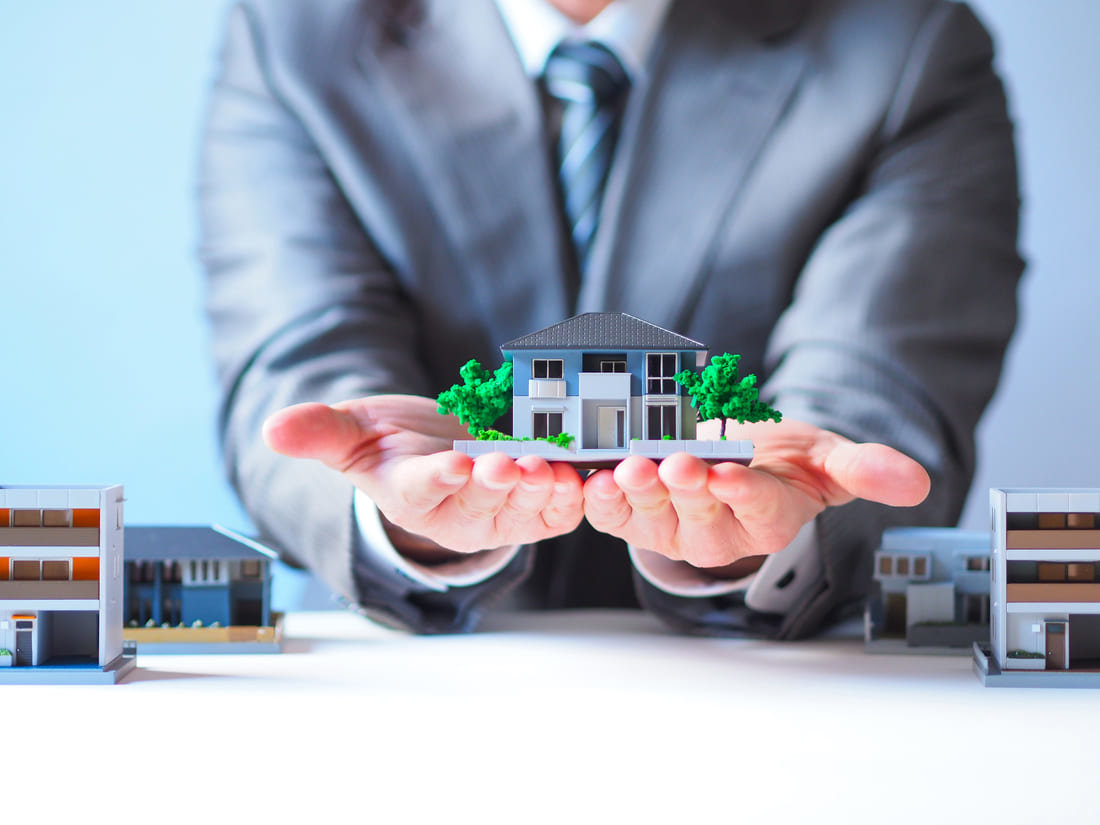 Man holding a model of a home to represent property management