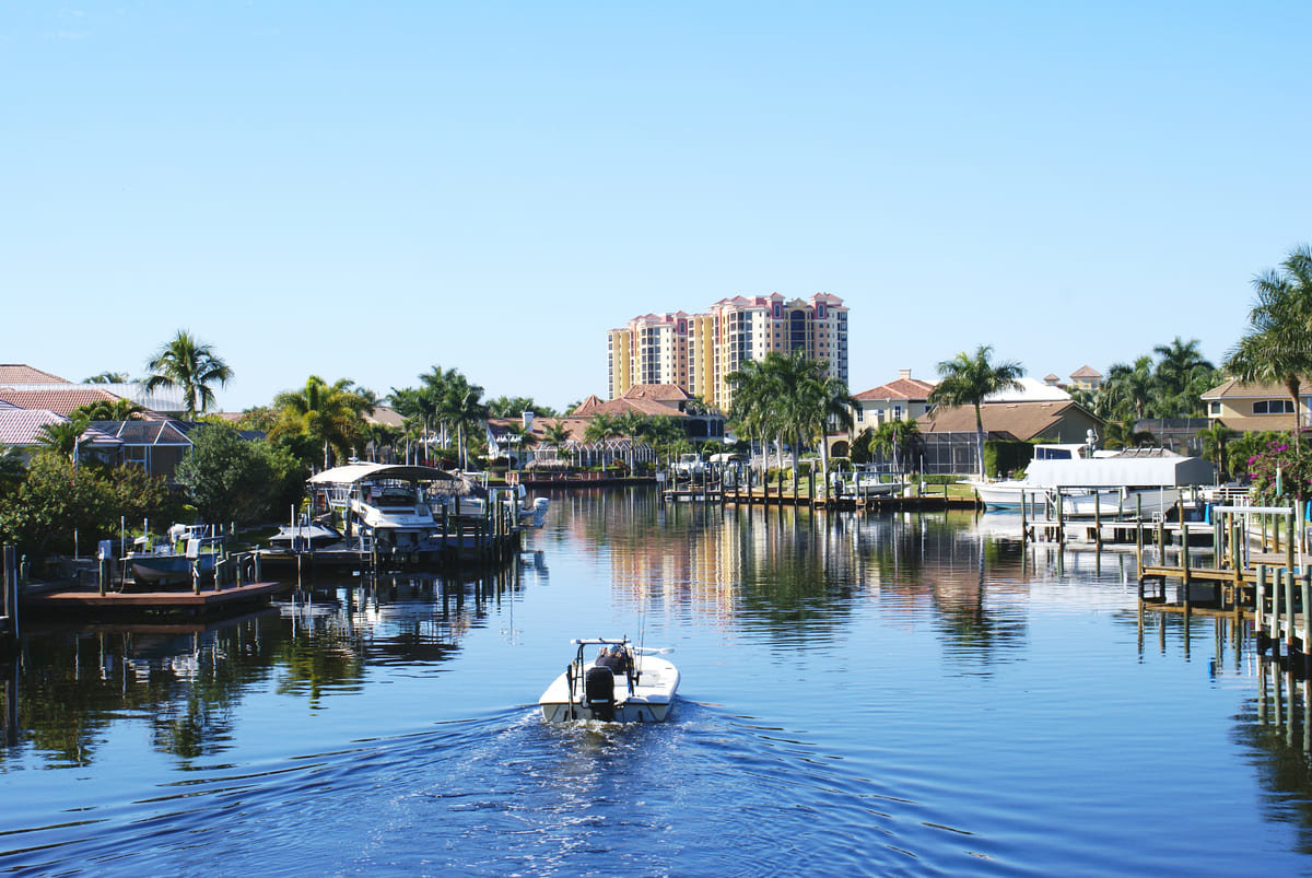 A boat gliding along the water in Cape Coral, FL.