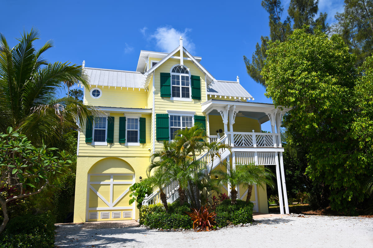 A beautiful yellow Florida home from the curb.
