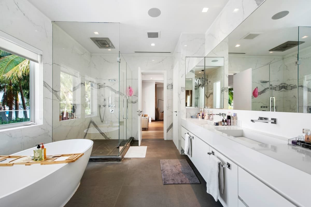 A beautiful Floridian bathroom with the doors open during the day time.