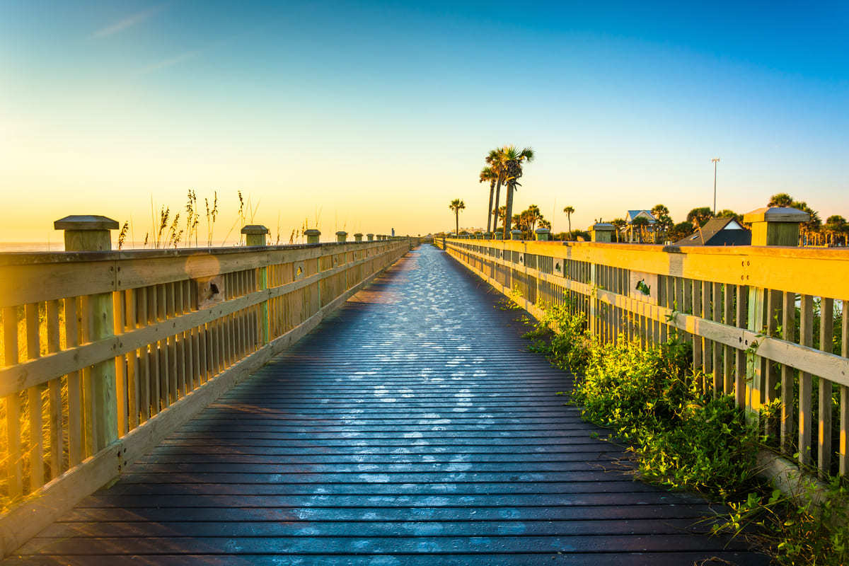 A walkway to a Palm Coast, FL beach during dusk.